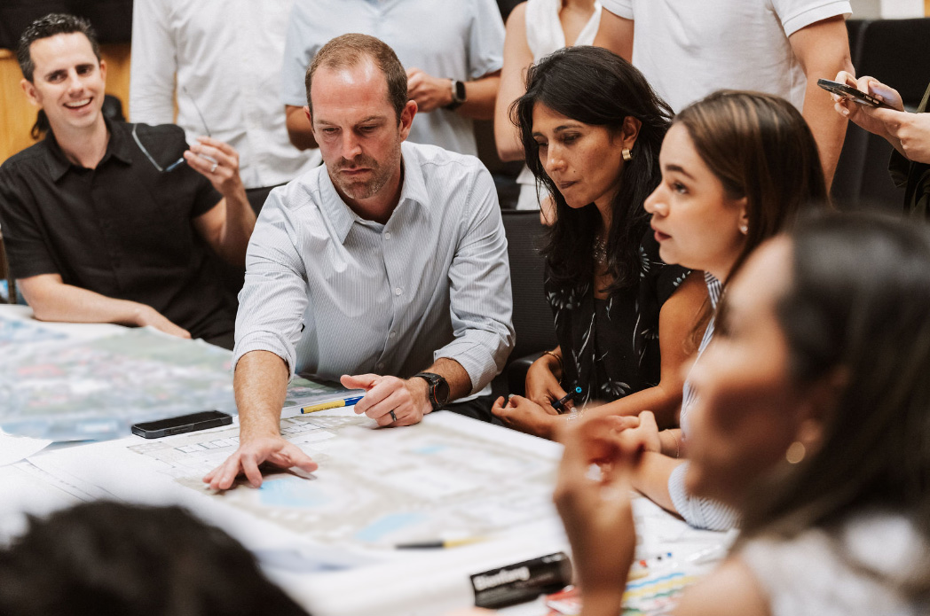 Equipo de trabajo participando en una sesión colaborativa, analizando información y discutiendo ideas durante un workshop estratégico.
